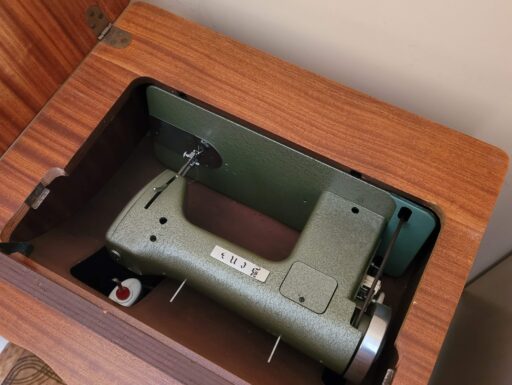 Mobile in radica con macchina da cucire antica antica